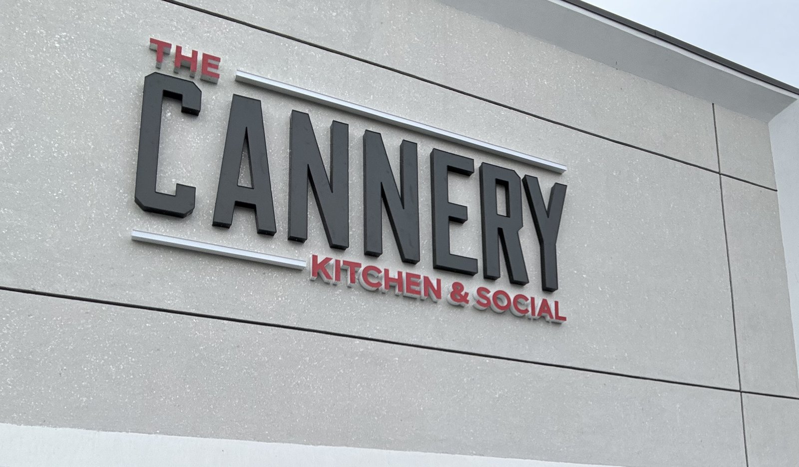 Commercial restaurant fit-out exterior, with branded company hardhat in foreground